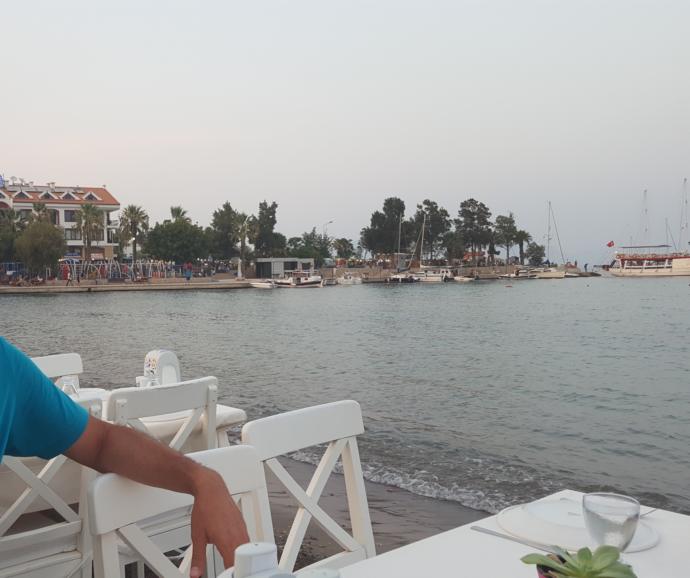 Akşam olunca kumsalın üzeri rengarenk ahşap masalarla donatılıyor