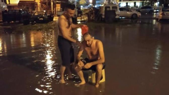 İzmir'de Sağanak Nedeniyle Sular Kesilince Sokak Ortasında Yıkandılar