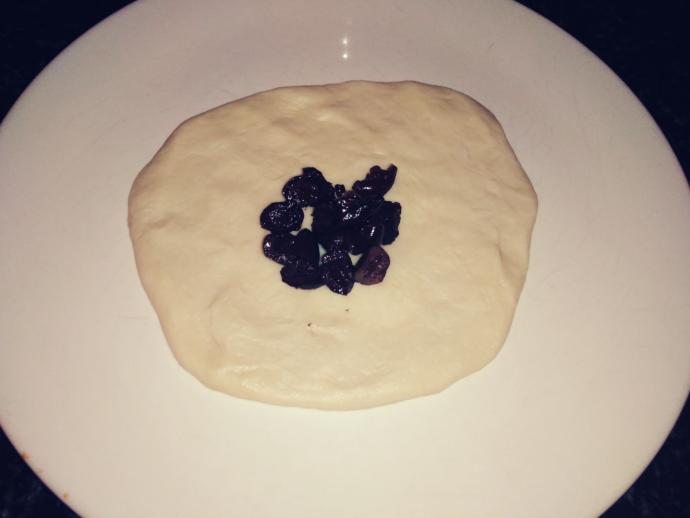 Hamuru elimizle açıp zeytin harcı koyuyoruz ve yuvarlıyoruz.