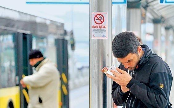 durakta sigara içen adam