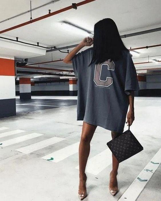 Oversize bir tişört elbise bacaklarla dengelenmiş.