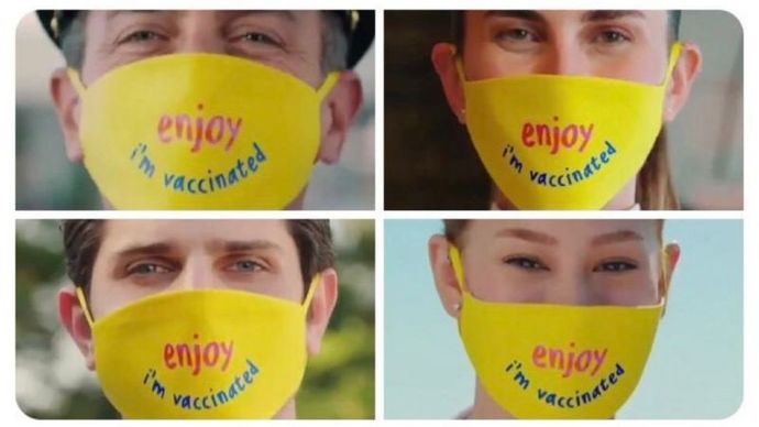 Turizm çalışanlarının maskesinde "İyi eğlenceler, ben aşılıyım." yazıyor.