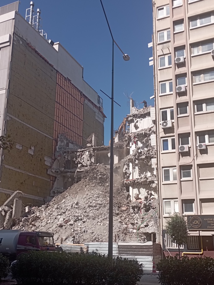 Yolun karşısındaki tüm esnaf dükkan önüne çıkmış izliyordu.